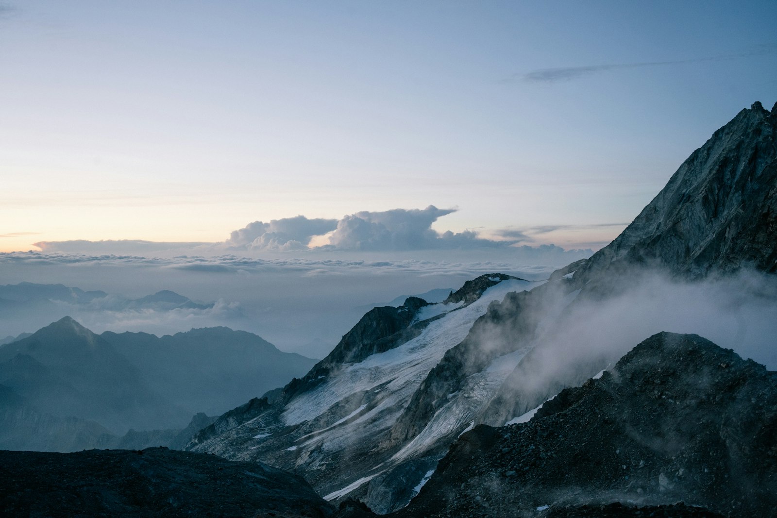Mountain peaks rising above a sea of clouds at dawn
